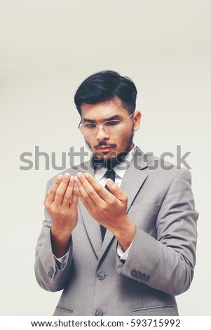 Businessman wearing a suit praying for god on gray background. Good luck