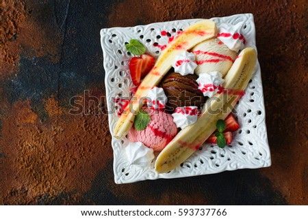 Delicious banana split ice cream dessert on grunge background. Space for text