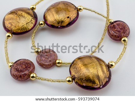 Glass - Murano gold bead necklace close up on white background