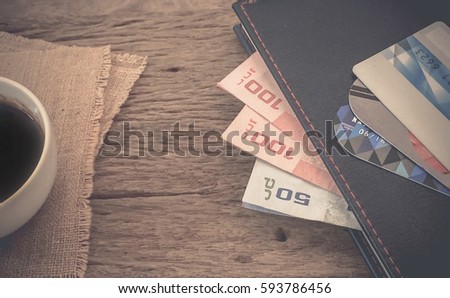 Banknotes and credit card on wood table surface background textured