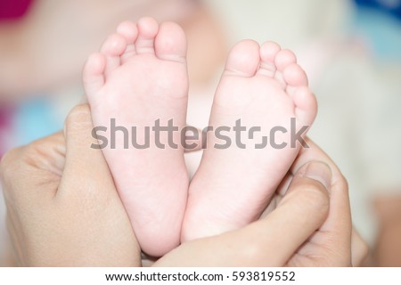 Mother hand hold baby toe close up