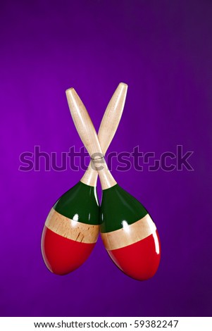 A pair of Latin maracas isolated against a purple background in the vertical format.