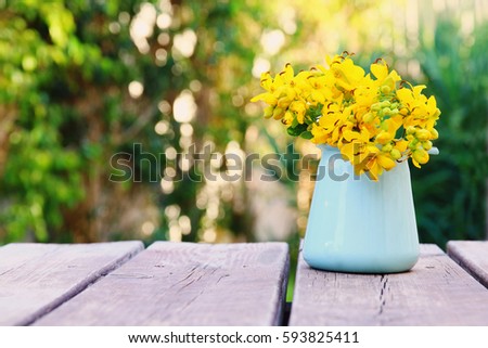 Beautiful field flowers on wooden table outdoors afternoon at sunset light. selective focus