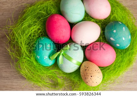 Easter composition of colored eggs cooked for the holiday on the wooden background