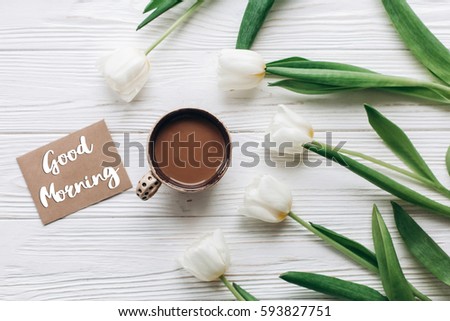 good morning text sign on greeting card at tulips with  coffee on white wooden rustic background with space for text. stylish flat lay with flowers and drink. hello spring. modern instagram photo