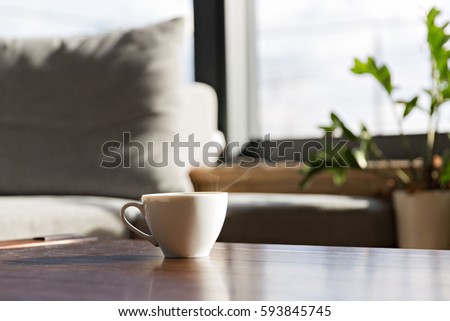 cup of fresh coffee standing on the table against window Royalty-Free Stock Photo #593845745