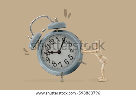Wooden dummy push a big clock, Isolated on brown background, Idea and concept of time picture.