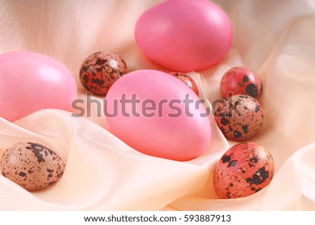 pink Easter eggs lying on a silk fabric.