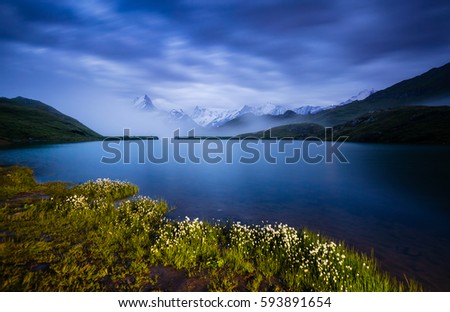 High mountain peaks glowing in the moonlight. Dramatic scene. Location place Bachalpsee in Swiss alps, Grindelwald valley, Bernese Oberland, Europe. Artistic picture. Discover the world of beauty.