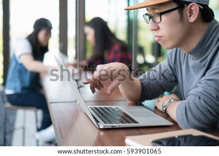 Smart man in casual style using laptop for work in coffee shop cafe.