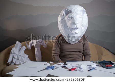 a man with a paper lion's head on the couch
