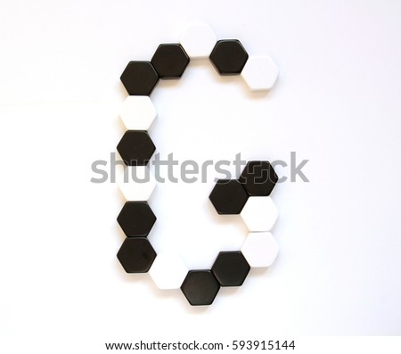 Black and white geometrical alphabet letters made of hexagonal figures laid side by side. Letter G