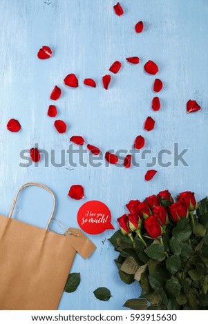 Heart of red rose petals on blue painted rustic background. Love shopping concept. I love you so much. Fresh natural bouquet of flowers.
