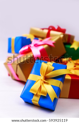 Gift boxes with bow. Colored presents wrapped with paper and ribbons. Christmas or birthday packages. Celebration design. On white table.
