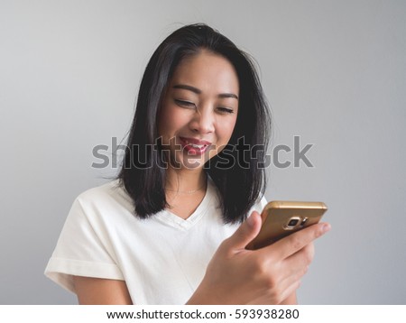 Asian woman look at smartphone and laugh.