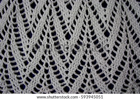 Crocheted handmade crochet from white thread on a black background