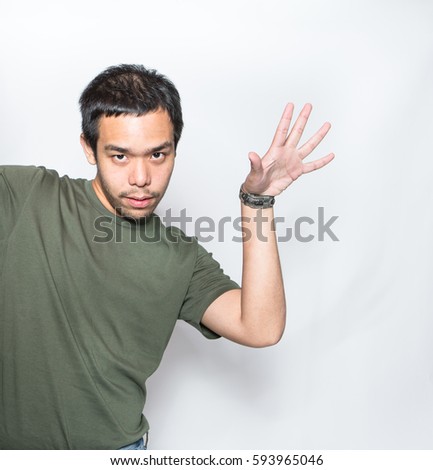 young cheeky Asian man do saltbae open palm of his hand like sprinkle or throw out something from his hand on white background in studio shot Royalty-Free Stock Photo #593965046
