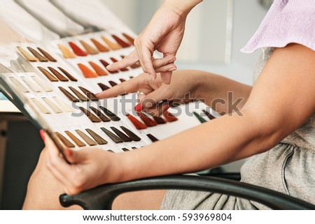 Young woman holding hair color swatches. 