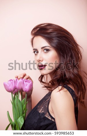 beautiful young woman with bunch of tulips on the wonderful pink background
