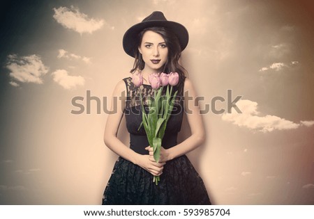 beautiful young woman with bunch of tulips on the wonderful blue background