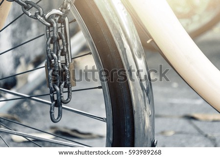 rusty padlock with a chain attached to a bicycle wheel