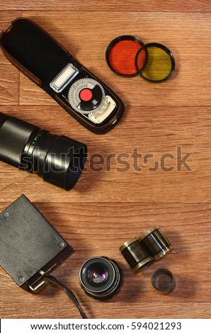 Top View of Vintage photo camera and other old retro photography accessories on wooden table with a lot of copyspace