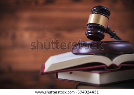 judge's gavel on top of pile of law books , studio picture on wooden background