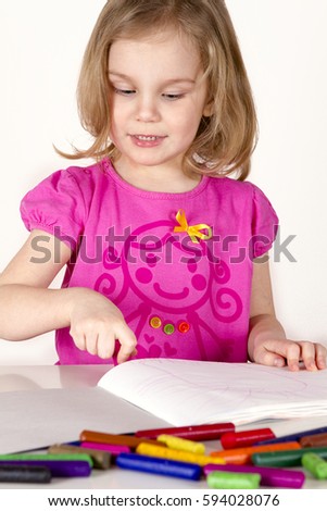 Cute little girl is drawing with pen in white background