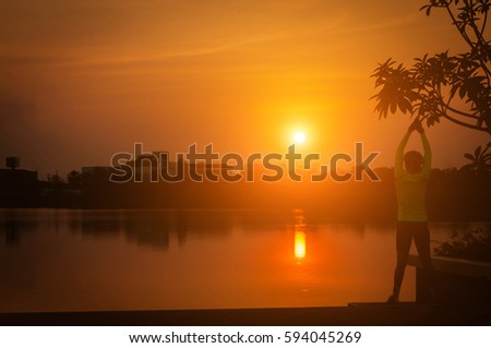Man exercise in park near lake at sunset/ sunrise,soft focus,silhouette style.