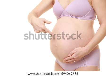 pregnant woman wearing underwear pointing to her stomach
