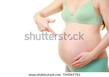 pregnant woman pointing to her stomach in studio shot on white background??