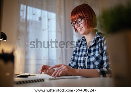 Photo of a young woman working at home.