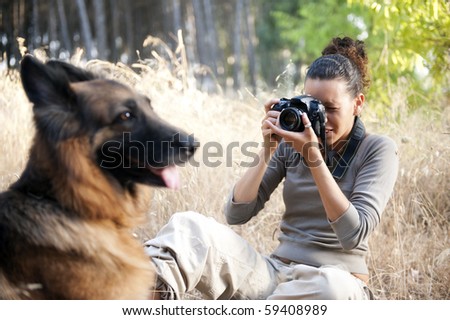 Young photographer taking a photo of her dog