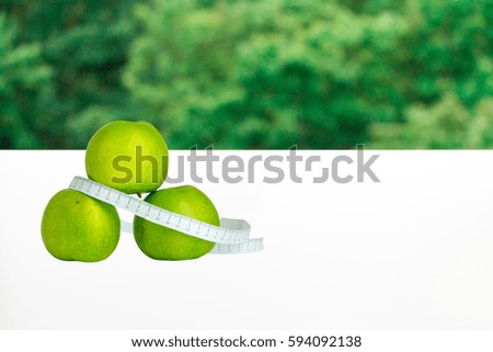 Green apples and measuring tape - concept of dieting and healthy lifestyle. copy space