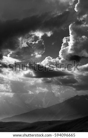 Black and white view on mountains in sunlight clouds. Caucasus Mountains. Georgia, region Svaneti.