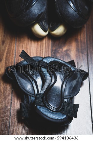 Protective wrist guard gloves and big black aggressive inline roller blades.Scratched wrist protection shields protect your palm from scratches,wounds and broken bones while skating on skates