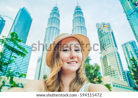 Young woman tourist making selfie on the background of skyscrapers. tourism, travel, people, leisure and technology concept.