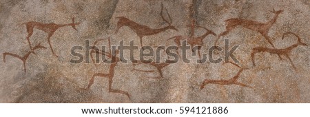 drawing on the wall in a cave, the rock. red ocher paint. Prehistoric man preys on animals deer. neanderthal, primitive, caveman, stone age, ice age. Royalty-Free Stock Photo #594121886