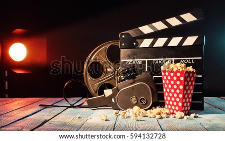 Retro film production accessories placed on wooden planks. Concept of film-making. Smoke effect with spot light on background