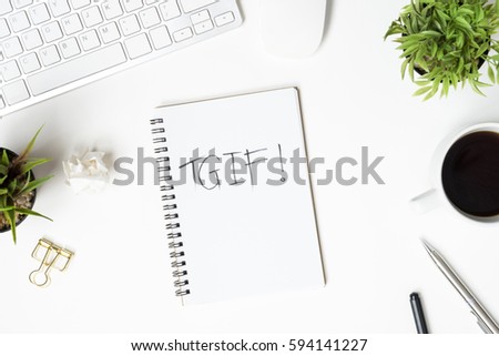 The notebook with TGIF text is on top of white office desk table. Top view, flat lay. Friday motivation concept. Royalty-Free Stock Photo #594141227