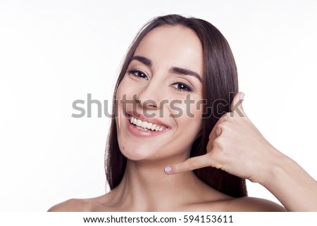 Beauty Spa Woman with perfect face skin Portrait. Proposing a product. Gesture for advertisement. Isolated on white. Beautiful brunette girl with straight hair speaks on imaginary phone.
