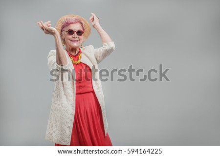 Happy beautiful senior lady wearing sunglasses and hat