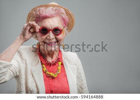 Funny senior lady looking at camera Royalty-Free Stock Photo #594164888