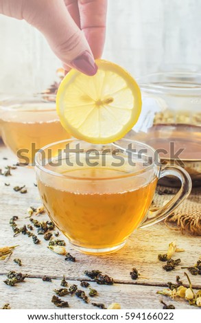Green tea with Jasmine and black with transparent lemon in a small Cup on a light background. The tea maker. Selective focus. 