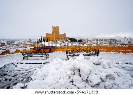 Snowy landscape of a medieval spanish village with a castle 