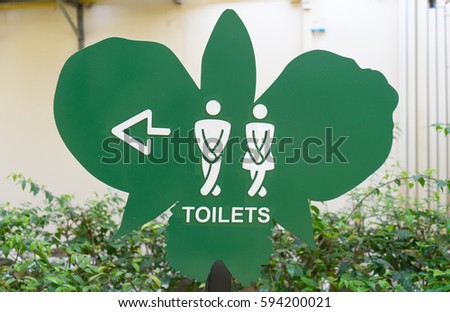Man and a lady toilet sign in orchid plant