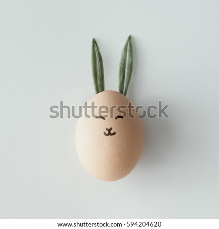 Easter egg with bunny ears and face. Flat lay. Minimal concept.