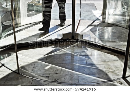 Feet walking in revolving door. Royalty-Free Stock Photo #594241916