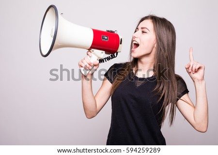 Pretty girl shouting into megaphone on copy space Royalty-Free Stock Photo #594259289