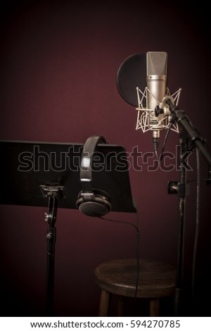 Voice recording studio set up, with microphone, music stand and headphones, vertical